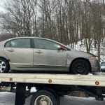 2005 Honda Civic sitting on the back of the Cash 4 Cars flatbed truck, purchased in Hilton, NY.